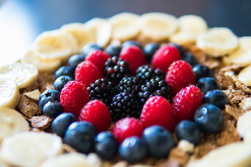 Cereals and fruits superbowl, healthy bowl breakfast with flakes, oat and fruits: raspberries, blueberries, banana, blackberries