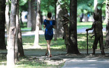 a girl in a blue dress is walking along the alley