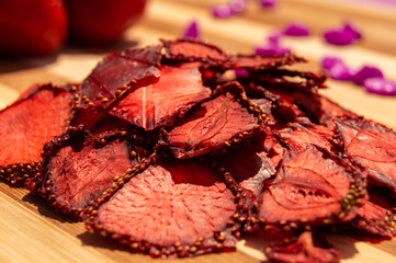 Dried strawberry on a wooden background closeup. Strawberry chips. Healthy food, diet, berries, summer snack, proper nutrition.
