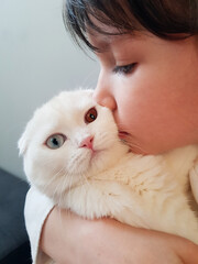 girl with a cat.
Little girl hugs, kisses a white cat. Love for pets.