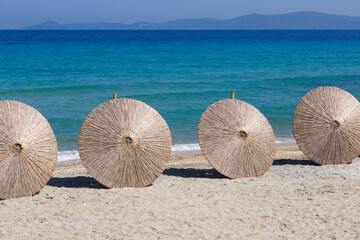 Straw beach umbrellas from the sun are prepared for the closing of the beach season