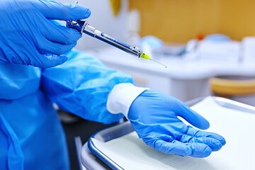 Doctor with syringe. Dental anaesthesia.  hands in blue protective gloves with anaesthesia syringe.   - obrazy, fototapety, plakaty