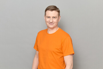 Portrait of happy blond mature man wearing orange T-shirt