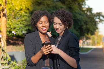 Businesswomen using cellphone resources.