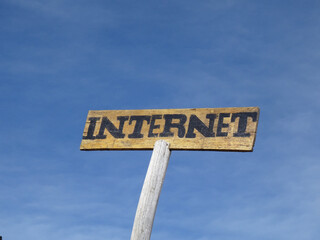 Old wooden sign internet in the middle of nowhere. Sky in the background 