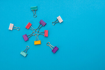 Star shapes made of ten binder clips on blue background