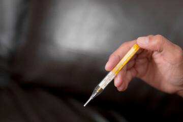 A woman's hand holding a thermometer.