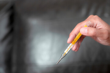 A woman's hand holding a thermometer.