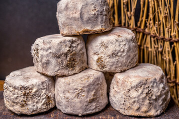 French cheese Crottin de Chavignol in the dark background. High quality photo