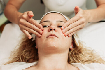 Obraz na płótnie Canvas Close-up of face massage treatment. Young Caucasian woman. Beauty treatments