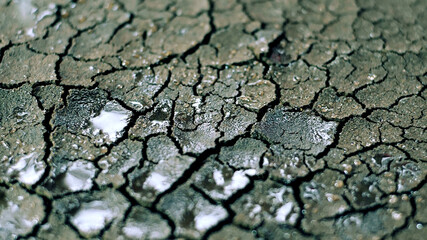 Water Drops Fall On Dry Fractured Soil Of Drought