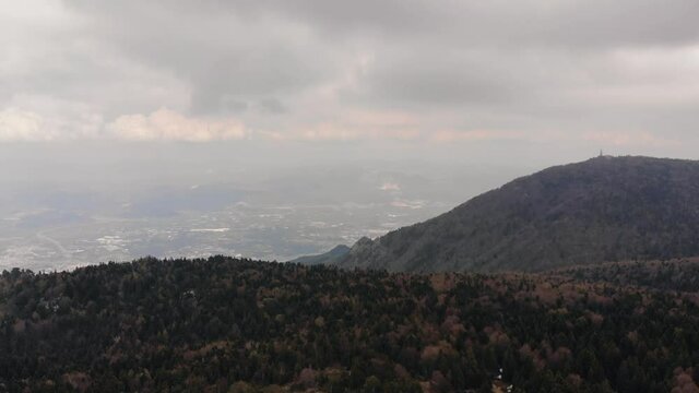 Hills covered with green spruce trees in the background of endless sky. Beautiful clouds above forest in Uludag