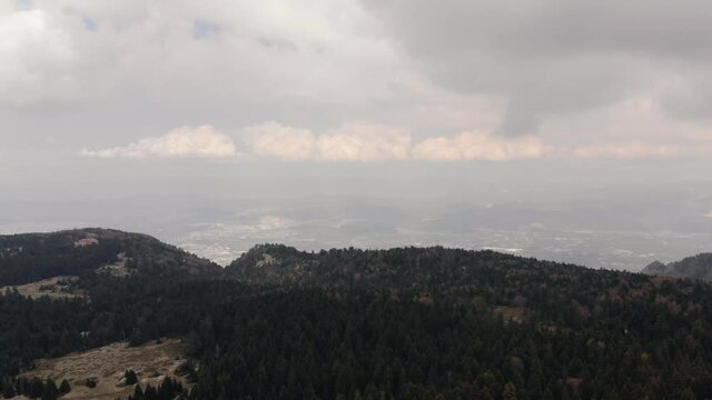 Hills covered with green spruce trees in the background of endless sky. Beautiful clouds above forest in Uludag