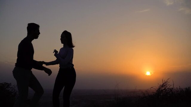 Young passionate couple of professional dancers dancing at sunset