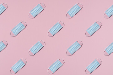 medical masks lie in rows diagonal on pink background top view pattern