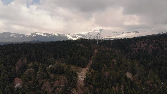 Coniferous forest in the background of snow-clad mountains of Uludag, Bolu. Aerial view 4K