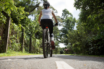 Fototapeta na wymiar Woman riding on bike path at park on sunny day