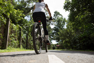 Woman riding on bike path at park on sunny day