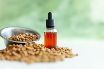 metal bowl with animal feed and a jar of CBD oil