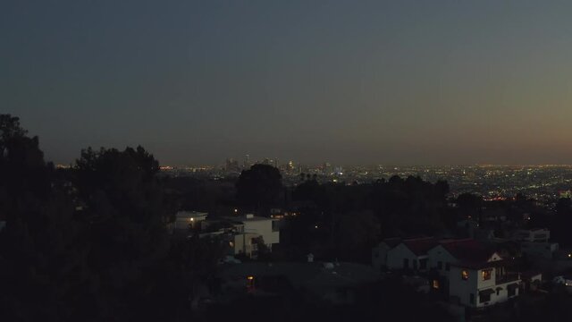 AERIAL: Over Hollywood Hills at Night with view on Downtown Los Angeles view, 