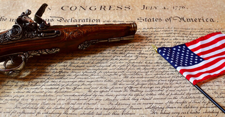 Declaration of Independence with a period flintlock pistol and an American flag.