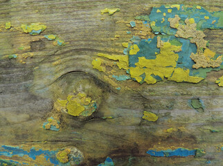 Wooden background with old turquoise, green and yellow paint, closeup
