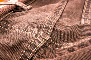 clothing items stonewashed cotton fabric texture with seams, clasps, buttons and rivets, macro