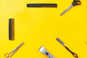 Composition with scissors and other hairdresser's accessories on yellow background, top view