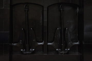 Two black anchors in the niches of the facade of the building