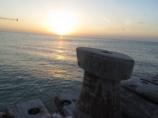 Muelle al atardecer con una bita para amarrar el barco