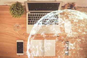 Social network hologram drawings over computer on the desktop background. Top view. Multi exposure. Concept of people connection.