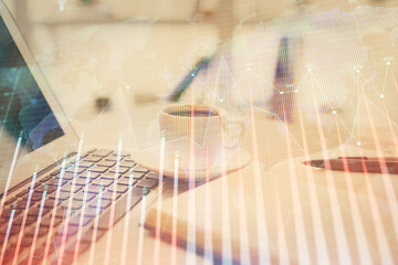 Double exposure of financial chart drawing and desktop with coffee and items on table background. Concept of forex market trading