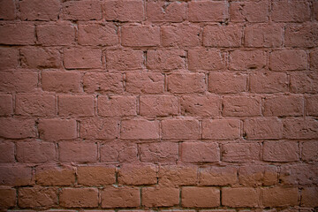 Old brick wall of a building, red, under the paint. Textured background. High quality photo
