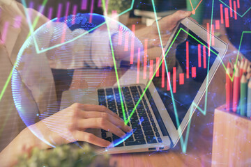 Double exposure of woman hands typing on computer and forex chart hologram drawing. Stock market invest concept.