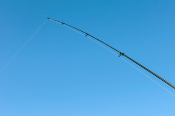 Fishing rod on the blue sky.