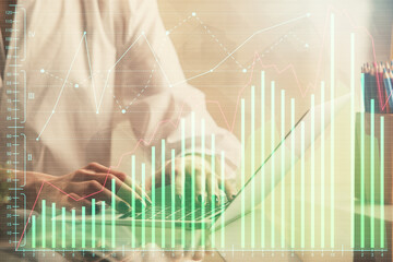 Double exposure of woman hands typing on computer and forex chart hologram drawing. Stock market invest concept.