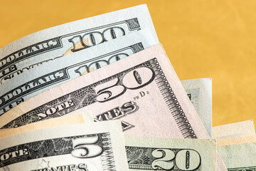 Many american dollar banknotes corner on the golden background. 