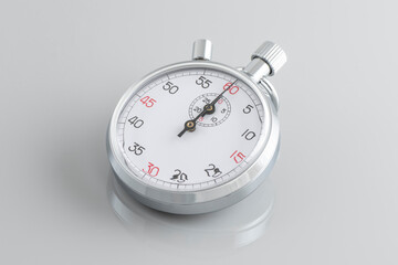 Analogue metal stopwatch on the gray background.