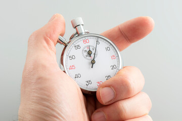 Man holding analogue stopwatch on the white background.
