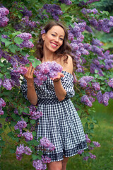 beautiful curly haired girl with a smile on her face in blooming lilac