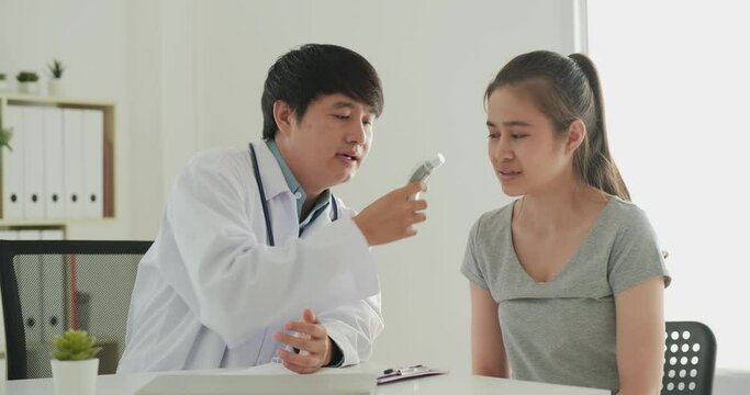 Female patient visiting male doctor at clinic. They talking about problem and doctor advice her in this case.