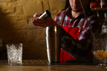 Bartender preparing fresh alcoholic cocktail at bar counter, closeup