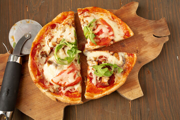 Sliced all dressed pizza with basil, herbs and tomato and cutter