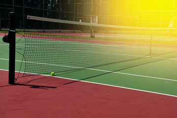 Closeup of Tennis Racket and balls on Tennis Courts in the outdoors.