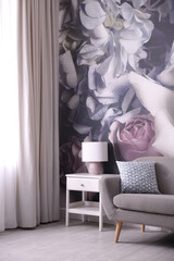 Modern sofa near wall with floral wallpaper. Stylish living room interior