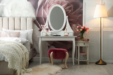 Stylish bedroom interior with elegant dressing table and floral wallpaper
