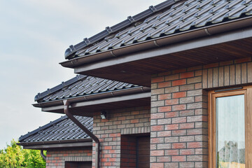 Fragment of the red ceramic tiled roof of the brick house