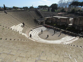 The Great Theatre of Pompeii with tourists walking around and sitting in Italy