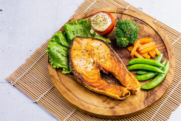 Salmon steak on wooden plate