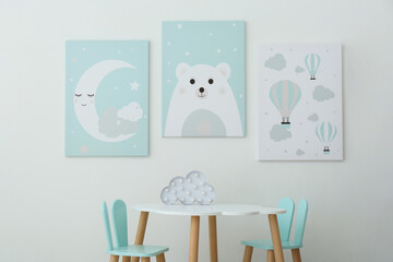 Adorable wall art, table and chairs with bunny ears in children's room interior